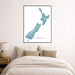 Framed map of New Zealand on a wall above a bed