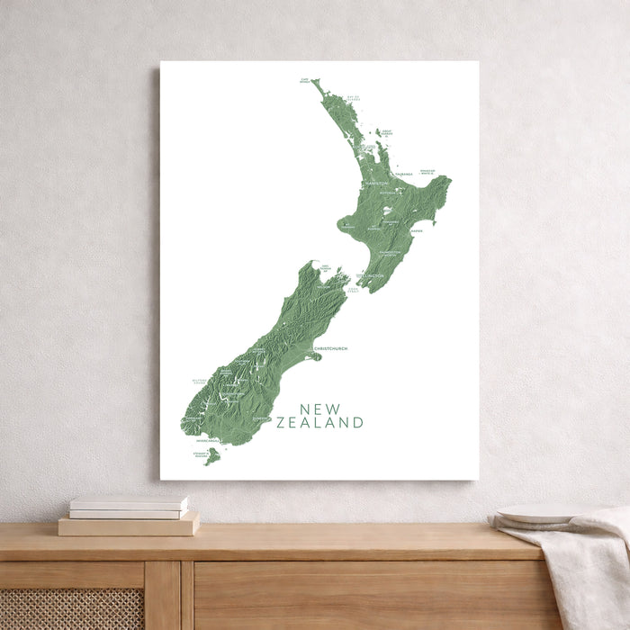 Map of New Zealand on a white wall above a wooden shelf.