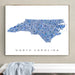 Framed map of North Carolina on a wall above a bench.