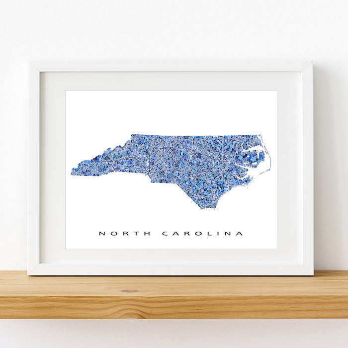 Framed map of North Carolina with a blue mosaic pattern on a white background