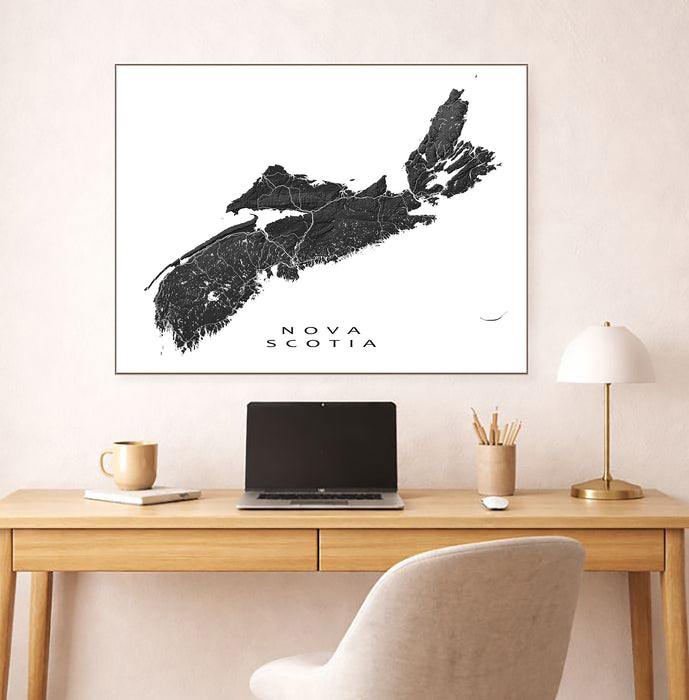 Map of Nova Scotia on a wall above a desk with a laptop and lamp.