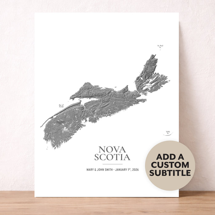 A custom Nova Scotia topographic map art print displayed on a light wood surface against a textured beige wall. The print features a detailed gray map of Nova Scotia on a white background with the text 'NOVA SCOTIA' and a custom date.