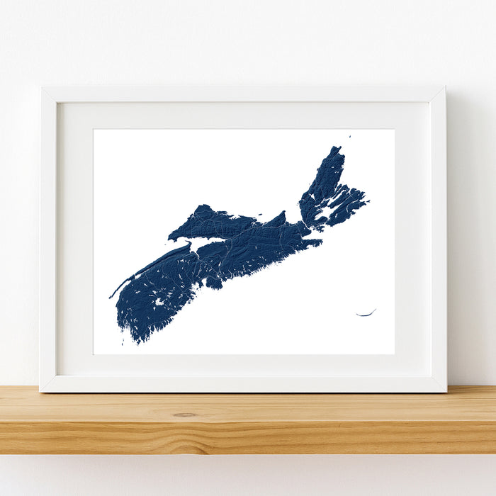 A framed minimalist map print of Nova Scotia in dark navy blue on a white background, displayed in a white frame on a light wood shelf against a white wall.