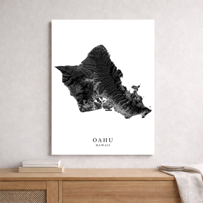 Map of Oahu, Hawaii on a white background in a frame on a wooden surface.