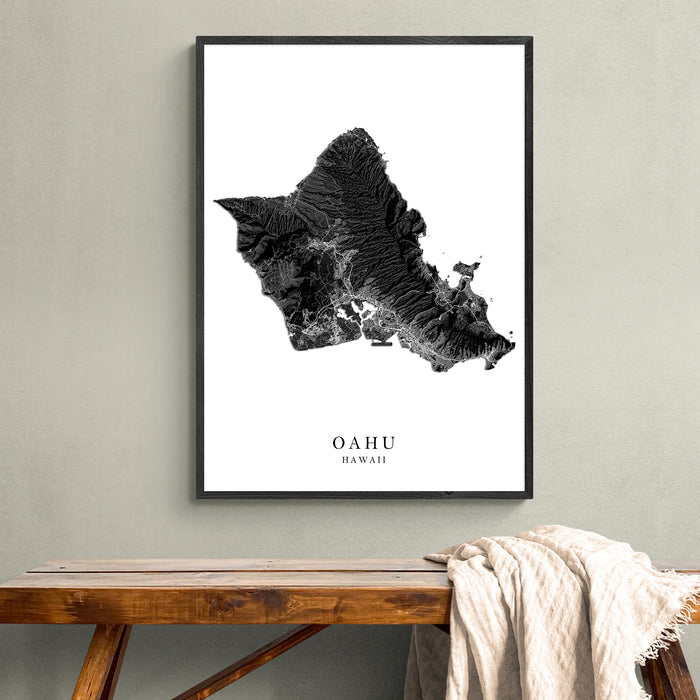 Framed map of Oahu, Hawaii on a wall above a wooden bench.