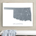 Framed map of Oklahoma on a wall above a white bench.