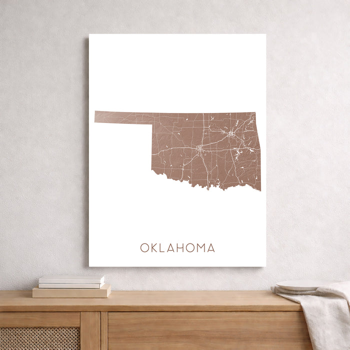 Map of Oklahoma on a white background, framed and leaning against a light gray wall.
