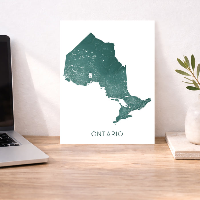 Map of Ontario on a desk with a laptop and plant