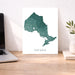 Map of Ontario on a desk with a laptop and plant