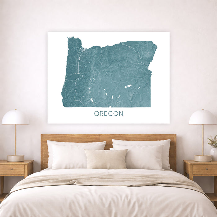 Map of Oregon on a wall above a bed in a bedroom setting