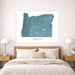 Map of Oregon on a wall above a bed in a bedroom setting