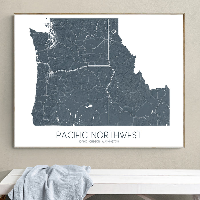Framed map of the Pacific Northwest on a wall above a white surface.