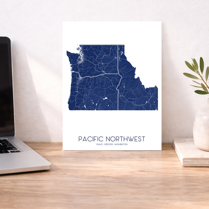 Map of Pacific Northwest on a desk with a laptop and plant