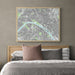 Framed city map above a bed with pillows