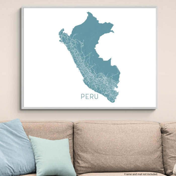 Framed map of Peru on a wall above a beige sofa with light blue pillows.