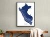 Framed map of Peru on a wall above a wooden table.