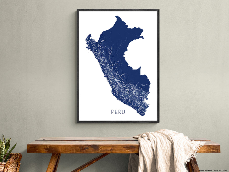 Framed map of Peru on a wall above a wooden table.