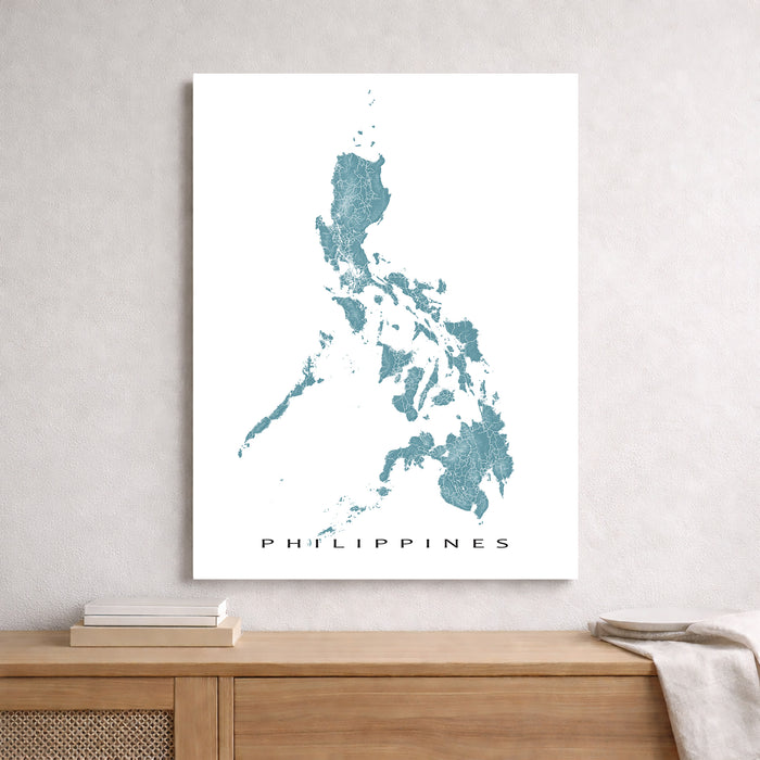 Map of the Philippines on a white wall above a wooden shelf.