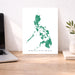 Map of the Philippines on a white background displayed on a wooden desk.