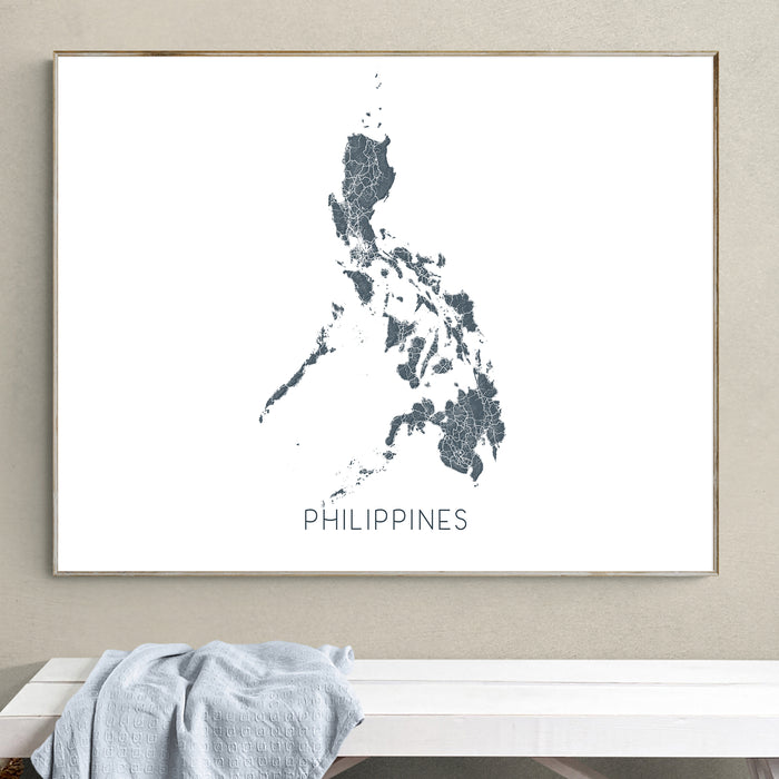 Framed map of the Philippines on a wall above a white bench.