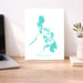 Map of the Philippines on a white background next to a laptop and plant on a wooden desk.