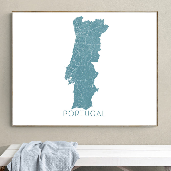 Framed map of Portugal on a wall above a white bench.