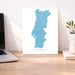 Map of Portugal on a desk with a laptop and plant