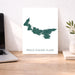 Map of Prince Edward Island on a white background, displayed on a wooden desk with a laptop and plant.