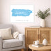 Living room with a gray sofa, wooden cabinet, and a framed map of Puerto Rico on the wall.