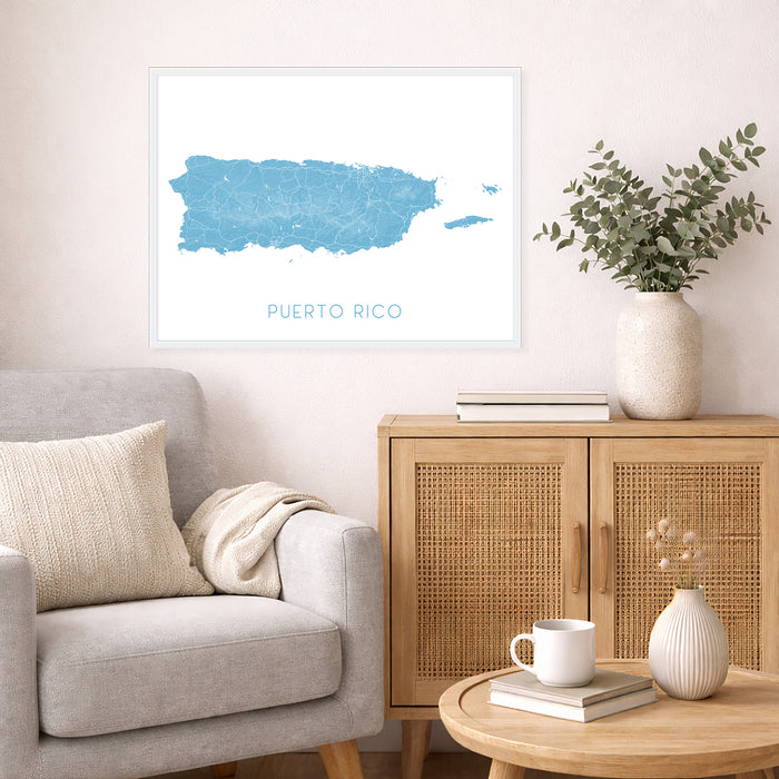 Living room with a gray sofa, wooden cabinet, and framed map of Puerto Rico on the wall.