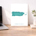 Map of Puerto Rico on a white background next to a laptop on a wooden desk.