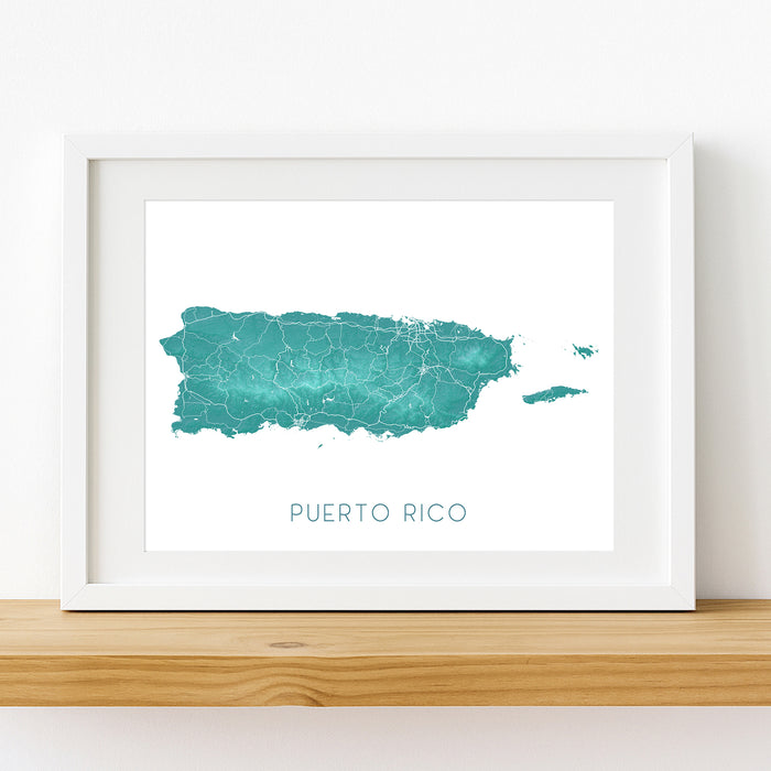 Framed map of Puerto Rico with a white border on a wooden surface.