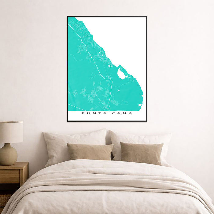 Framed map of Punta Cana on a wall above a bed.