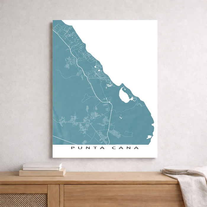 Map of Punta Cana on a white wall above a wooden shelf.