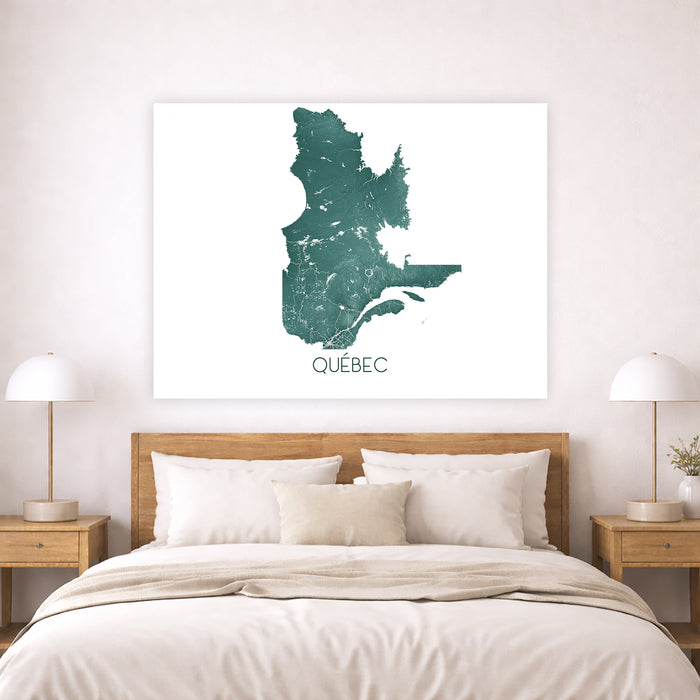 Framed map of Quebec on a wall above a bed in a bedroom.