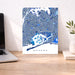 Map of Queens on a wall above a desk with a laptop and plant.