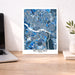 Map poster of Richmond, Virginia on a desk with a laptop and plant.