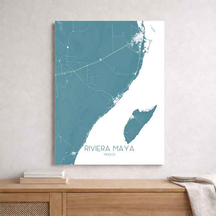 Map of Riviera Maya, Mexico on a white wall above a wooden surface.