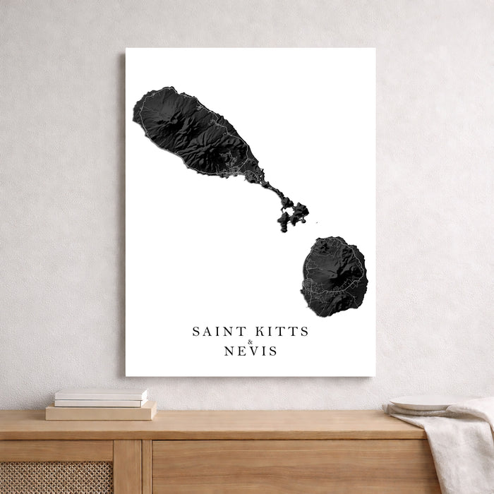 Map of Saint Kitts and Nevis on a white background, framed on a wall above a wooden shelf.