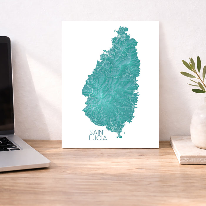 Map of Saint Lucia on a white background next to a laptop and plant.