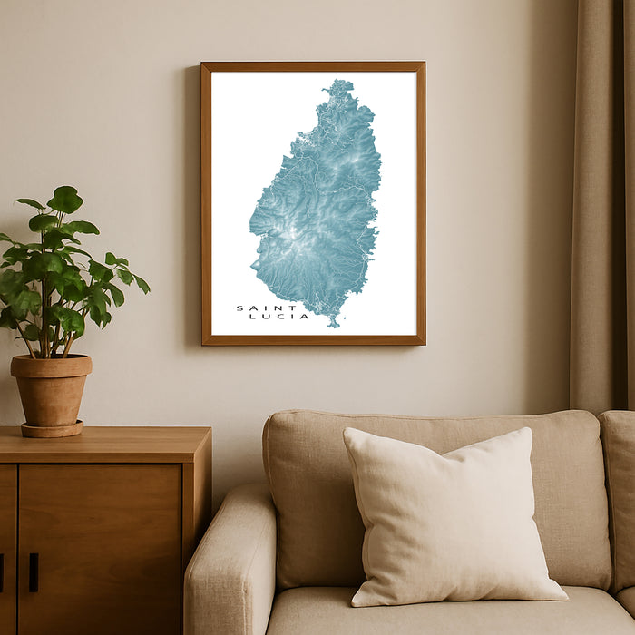 Framed map of Saint Lucia on a wall above a sofa with a plant beside it.