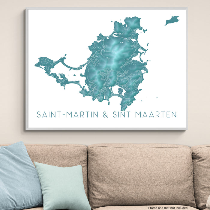 Framed map of Saint-Martin & Sint Maarten on a wall above a beige sofa with light blue pillows.