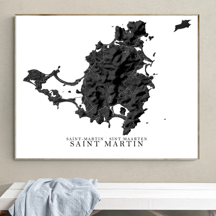 Framed black and white map of Saint Martin on a wall above a white bench.