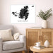 Living room with a framed black and white map of Saint Martin on the wall, a beige armchair, wooden cabinet, and small table with decor items.