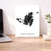 Map of Saint Martin on a white background next to a laptop on a wooden desk.