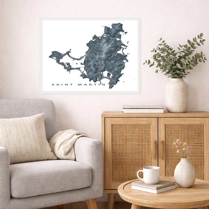 Living room with a map of Saint Martin on the wall, a couch, and a side table with a plant and books.