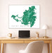Framed map of Saint Martin on a wall above a desk with a laptop and office items.