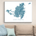 Map of Saint Martin framed on a wall above a beige sofa with light blue pillows.