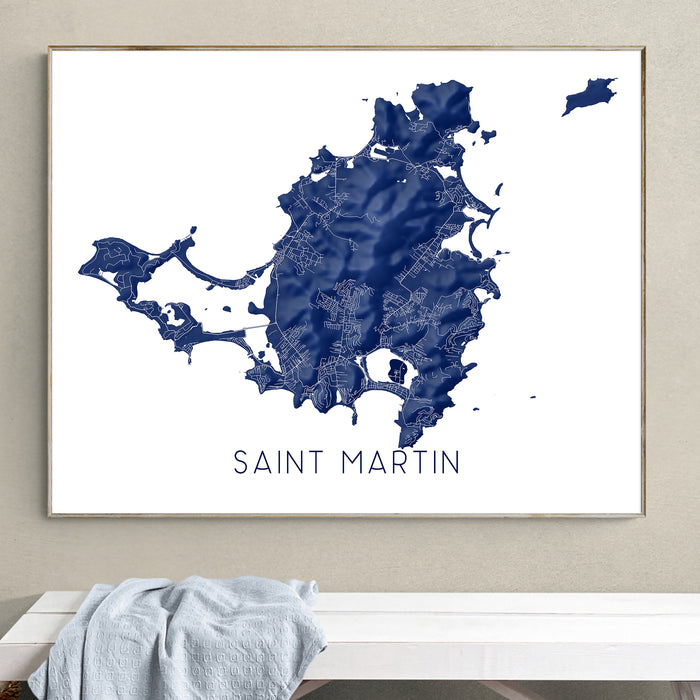 Framed map of Saint Martin on a wall above a white bench.