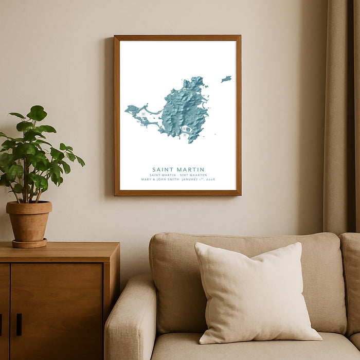 Framed map of Saint Martin on a wall above a sofa with a plant beside it.